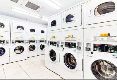 a row of white washing machines in a laundrette at Castle 1029 Balcony studio with Ocean View, Pool, Tennis and Free Parking in Miami Beach