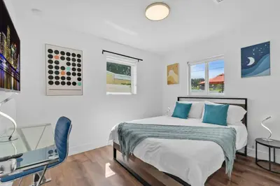 a white bedroom with a bed and a desk at Escape to Private Poolside Bliss in Hollywood