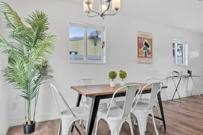 a dining room with a wooden table and white chairs at Escape to Private Poolside Bliss in Hollywood