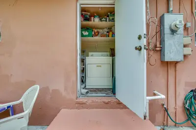 an open door to a kitchen with a washer and dryer at 4 Mi to Beach Hollywood Home with Patios! in Hollywood