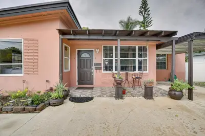 a pink house with a front porch with plants at 4 Mi to Beach Hollywood Home with Patios! in Hollywood