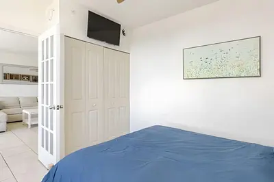 a bedroom with a bed and a tv on the wall at Pavilion - Stunning bay view in Miami Beach