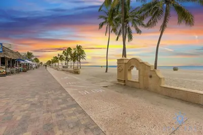 a street with palm trees on a beach with a sunset at Hot Tub - Hollywood Beach Boardwalk - Amazing Pool in Hollywood