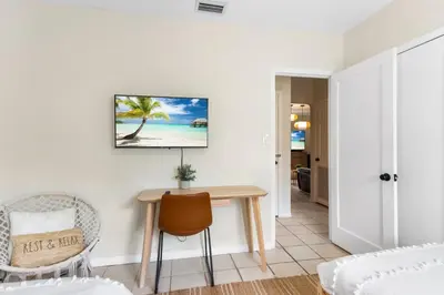 a living room with a table and a bed at 3BR Boho Style Home w Private yard & Firepit in Miami