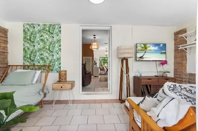 a bedroom with a bed and a desk and a mirror at 3BR Boho Style Home w Private yard & Firepit in Miami