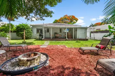 a backyard with a fire pit and chairs and a house at 3BR Boho Style Home w Private yard & Firepit in Miami