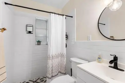 a white bathroom with a shower curtain and a sink at 3BR Boho Style Home w Private yard & Firepit in Miami