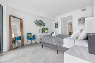 a white bedroom with a bed and a mirror at Exclusive High-Rise Edgewater 1BD - Tennis & Sauna in Miami