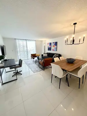 a dining room and living room with a table and chairs at 36th floor Brickell bay view 1BR 2 Queens and Sofa Bed in Miami