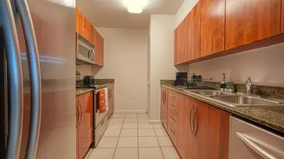 a kitchen with wooden cabinets and a stainless steel refrigerator at Beautiful Brickell Miami apt 2BR/2BA + Parking in Miami