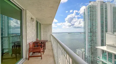 a balcony with a table and chairs and a view of the ocean at Beautiful Brickell Miami apt 2BR/2BA + Parking in Miami