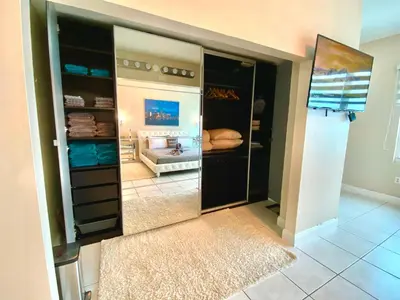 a walk in closet with a large mirror in a room at Large beautiful penthouse ocean front with beach access and free parking in Miami Beach in Miami Beach