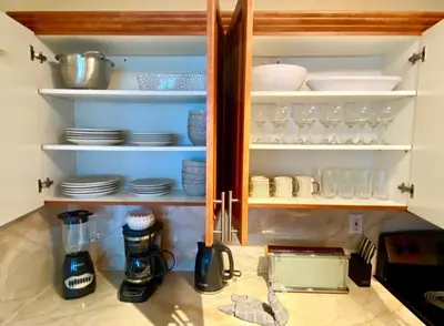 a kitchen cabinet with plates and dishes in it at Large beautiful penthouse ocean front with beach access and free parking in Miami Beach in Miami Beach