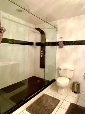 a bathroom with a toilet and a glass shower at Large beautiful penthouse ocean front with beach access and free parking in Miami Beach in Miami Beach