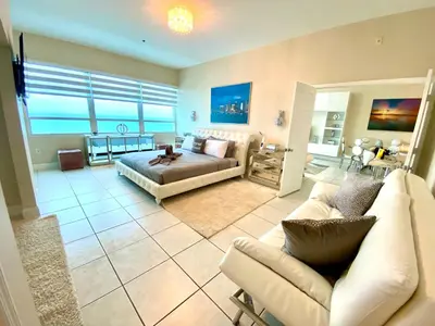 a large living room with a couch and a bed at Large beautiful penthouse ocean front with beach access and free parking in Miami Beach in Miami Beach