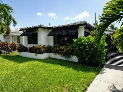 a house with a green lawn and a house at Quiet Oasis Steps From Shops with Golf View-CS61 in Hollywood