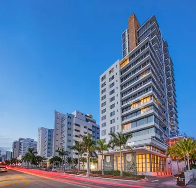 a tall building with palm trees in front of a street at Ocean 2 Sky at Monte Carlo Miami Beach in Miami Beach