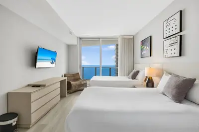 a hotel room with two beds and a tv at Elegant Beachfront Condo Offering Stunning Views in Hollywood