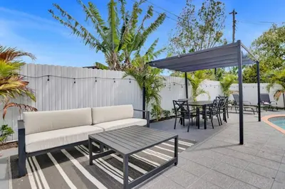 a patio with a couch and a table and chairs at Cozy Fun House 4 2 Aventura Stadium Beach in North Miami Beach
