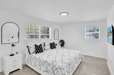 a white bedroom with a bed and windows at Cozy Fun House 4 2 Aventura Stadium Beach in North Miami Beach