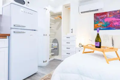 a bedroom with a bed and a table with wine glasses at Smart Tiny House Garden in Miami Gardens