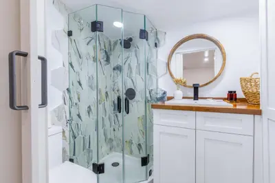 a bathroom with a shower with a sink and a mirror at Smart Tiny House Garden in Miami Gardens