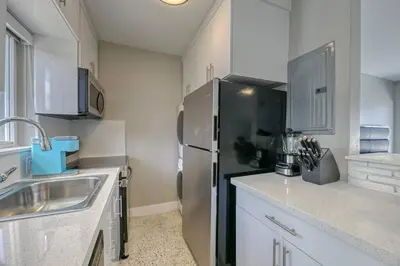 a kitchen with a black refrigerator and a sink at Sunshine Manor 2017-2 in Fort Lauderdale