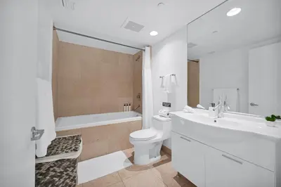 a white bathroom with a tub and a toilet and a sink at Stylish Studio Icon, W Hotel Waterfront Building in Miami