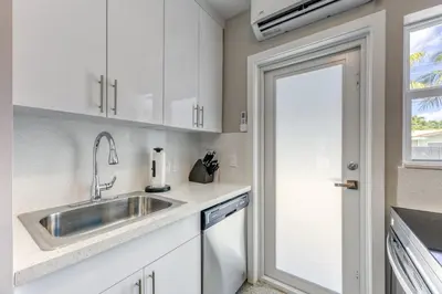 a kitchen with white cabinets and a sink at Sunshine Manors 2009 B in Fort Lauderdale