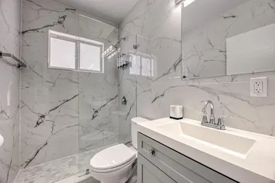 a white bathroom with a toilet and a sink at Sunshine Manors 2009 B in Fort Lauderdale