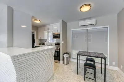 a kitchen with a counter and a table with a stool at Sunshine Manor 2017-1 in Fort Lauderdale