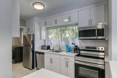 a kitchen with white cabinets and stainless steel appliances at Sunshine Manors 2017-3 in Fort Lauderdale