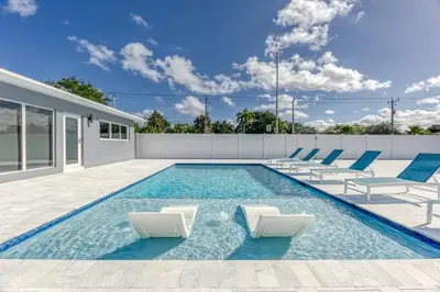 a swimming pool with lounge chairs and a house at Sunshine Manors 2009 A in Fort Lauderdale