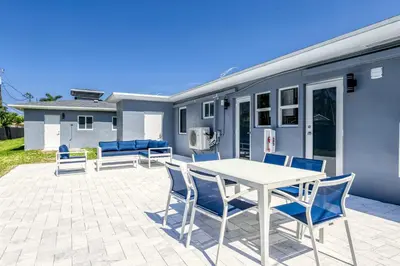 a patio with a white table and blue chairs at Sunshine Manors 2009 A in Fort Lauderdale