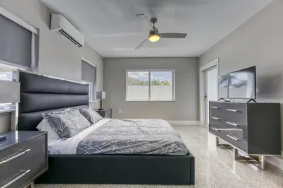 a bedroom with a bed and a dresser with a television at Sunshine Manors 2013 B in Fort Lauderdale