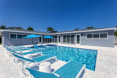 a swimming pool with chairs and a house at Sunshine Manors 2013 B in Fort Lauderdale