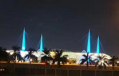 a building with blue lights on it at night at BOOK ME, 3mins Hard Rock Stadium in Miami Gardens