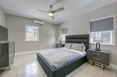 a bedroom with a bed and a dresser and a television at Sunshine Complex in Fort Lauderdale