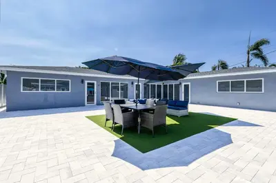 a patio with a table with chairs and an umbrella at Sunshine Complex in Fort Lauderdale