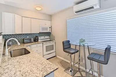 a kitchen with a sink and a table and chairs at Wiltonplex Complex in Fort Lauderdale