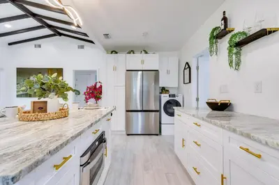 a kitchen with white cabinets and a refrigerator at Stylish Miami Home 2 Mi to Intracoastal Waterway! in Miami