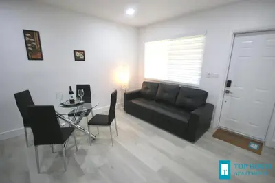 a living room with a black couch and a table at 251 Airport/Top House Apartments in Miami