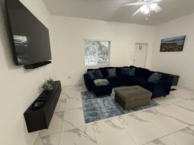 a living room with a blue couch and a tv at Mango Haus Near Beach, Cruise Port & Stadium in Fort Lauderdale