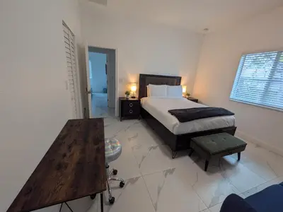 a bedroom with a bed and a wooden table at Mango Haus Near Beach, Cruise Port & Stadium in Fort Lauderdale