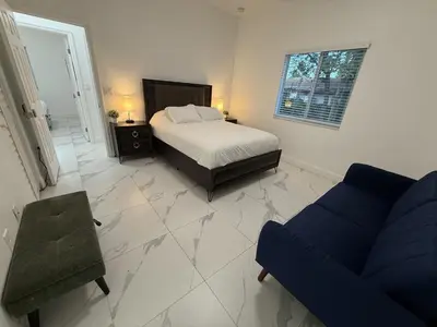a bedroom with a bed and a couch and a chair at Mango Haus Near Beach, Cruise Port & Stadium in Fort Lauderdale