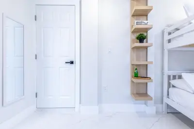 a white door in a white room with shelves at Serenity Lodge Condo in Miami