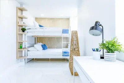 a room with bunk beds and a desk at Serenity Lodge Condo in Miami