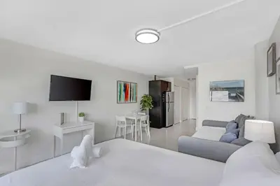 a white living room with a bed and a couch at Waterfront Studio Condo in the Heart of Miami - Skyline & Bay Views in Miami Beach
