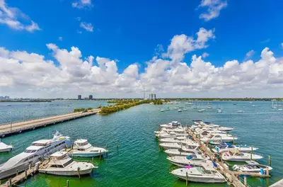 a group of boats docked at a dock in the water at Waterfront Studio Condo in the Heart of Miami - Skyline & Bay Views in Miami Beach