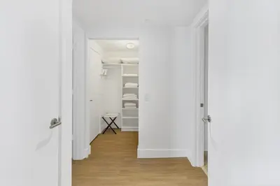 a hallway with white walls and a white closet at Ocean View Balcony with Pool Gym Access in Hallandale Beach